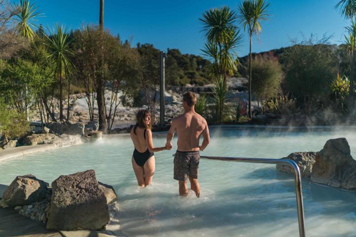 a man and a woman standing next to a river