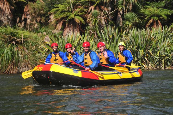 a group of people riding on the back of a boat in the water