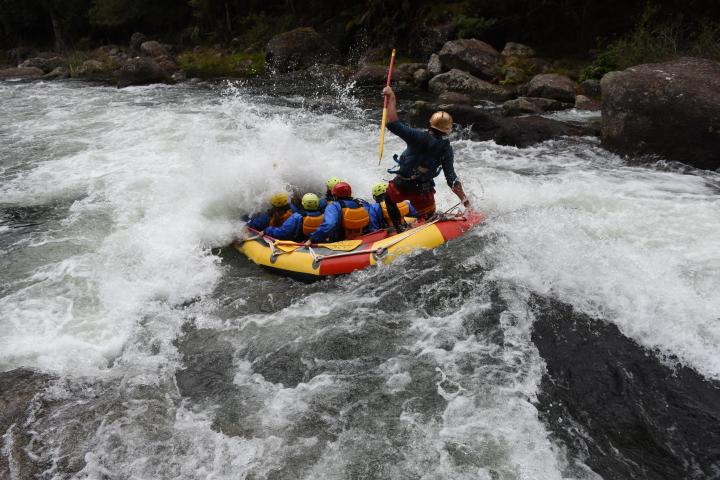 a man riding a wave on a raft in a body of water